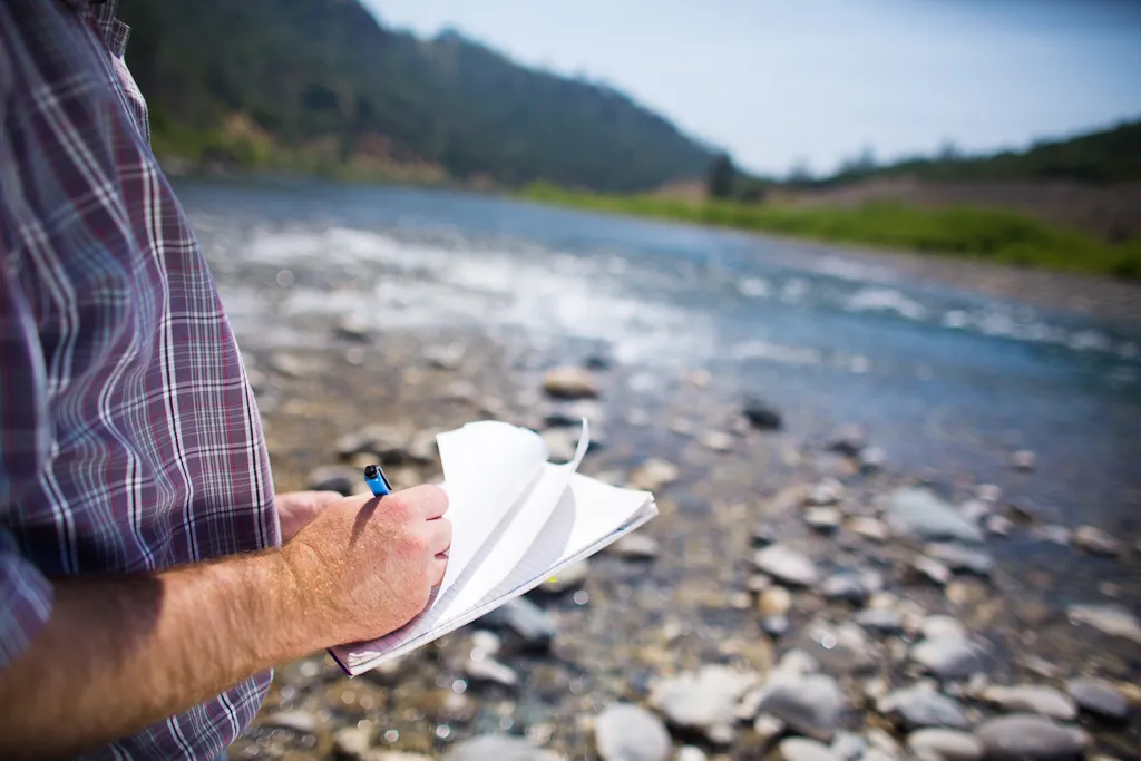 Researcher monitoring and taking fall run Chinook salmon spawning counts along the Yuba River at SFREC