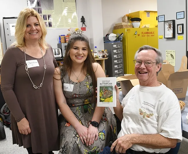 Author Lawrence "Larry" Allen shows his book to Christina Cunha (far left) of Modesto and her daughter, Madison Cunha, a self-described "aspiring entomologist." (Photo by Kathy Keatley Garvey)