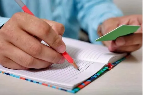 Man writing in booklet. Photo from pixabay.com.
