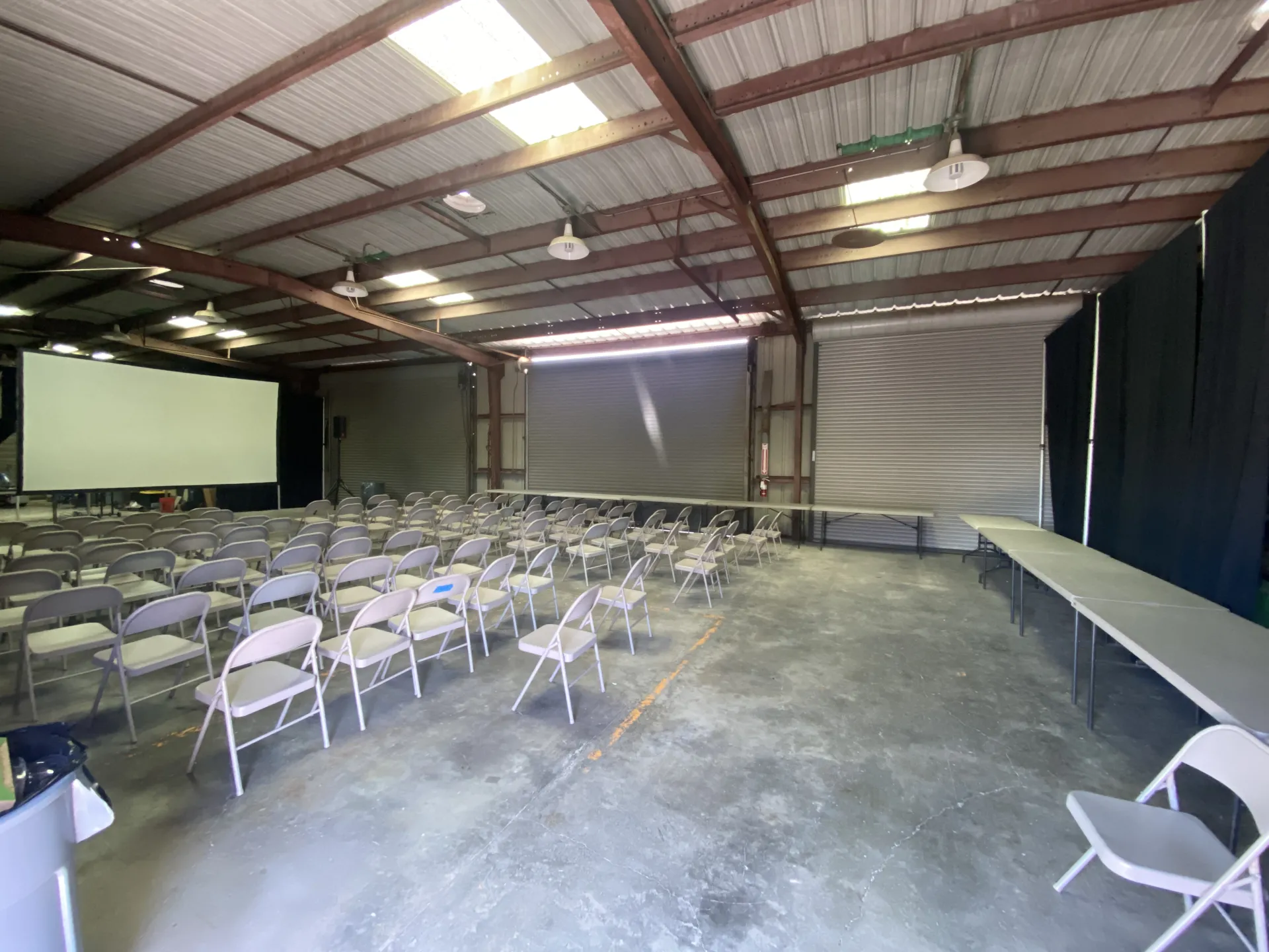 the barn set up with chairs and the projector screen for presentations, with tables around the perimeter for food and beverages
