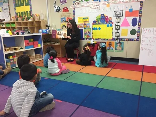 Cassie reads Potter the Otter to an elementary class