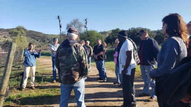 Ester field day participants are gathered outside for a demonstration.