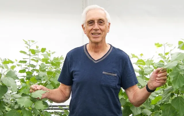 Norm Terry stands between two green plants.