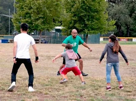 Kids exercise outdoors with an instructor