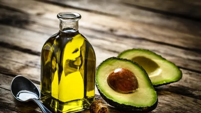 Bottle of avocado oil and an avocado cut open