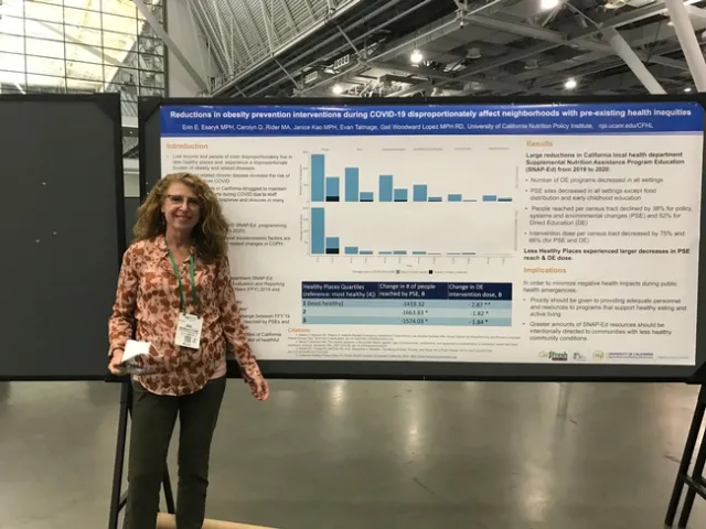 Gail Woodward-Lopez stands by a poster in Boston