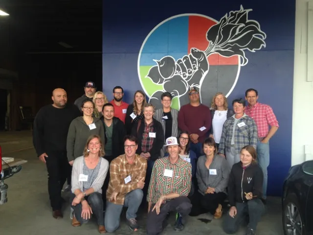 More than 20 people posing for a photo at a food distribution center.