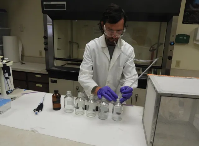 Michael Bollinger conducting mosquito bottle bio-assay.