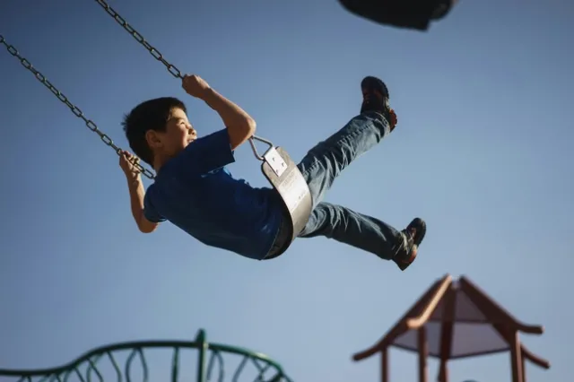 Boy swings high on swings