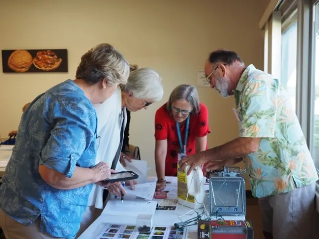 Group of people looking at items on a table