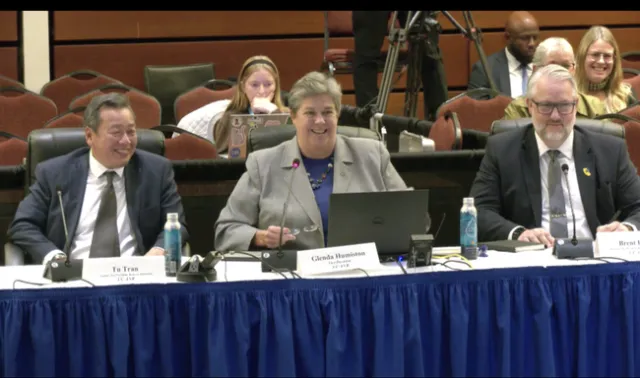 From left, Tu Tran, Glenda Humiston and Brent Hales are sitting at a long table and smiling.