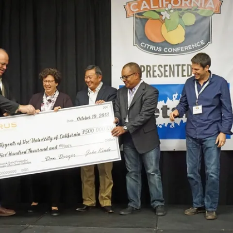 CRB chairman Dave Dreyer presents a giant check to UC Agriculture and Natural Resources representatives, left to right, LREC director Beth Grafton-Cardwell, associate vice president Tu Tran, UC ANR director of major gifts Greg Gibbs, and UCCE plant pathology specialist Georgios Vidalakis.