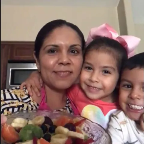 A family that attended class is showcasing their prepared Summer Fruit Salad recipe.