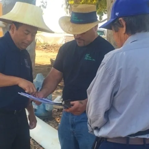 Especialista hablando con un granjero acerca de los método de riego