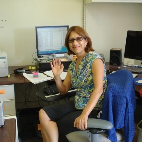 Norma sitting at her desk.