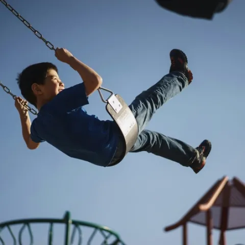 Boy swings high on swings