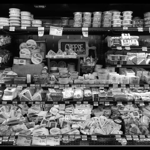 Black and white image of a grocery store cheese aisle