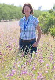Woman stands in crop field.
