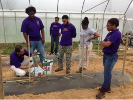 Díaz mostrando el uso del sistema de riego a estudiantes de la Universidad Estatal de Alcorn.