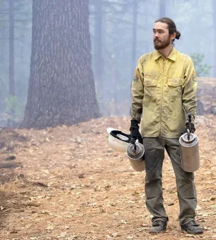 Kane Russell, administrador forestal interino en Blodgett, sostiene dos antorchas de goteo después de demostrar cómo son utilizadas para iniciar las quemas prescritas.