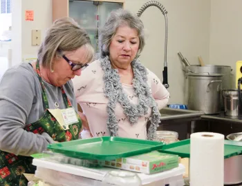 Two people are preserving foods in a class.