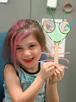 Soraya Qaqunah, 4, of Davis, shows her finished project. Her grandfather is Blake Temple, UC Davis distinguished professor of mathematics. (Photo by Kathy Keatley Garvey)