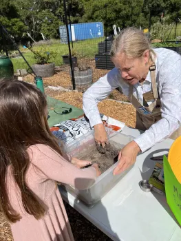 Master Gardener helping a child make a seed bomb