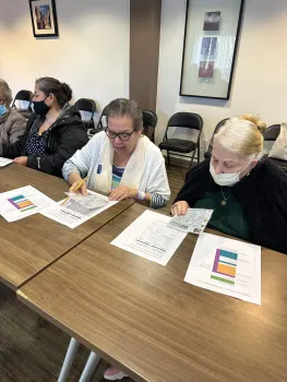 Older adults at Oaks on Florence sit at a table taking a nutrition class