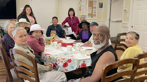 Twelve people of mixed races sitting around a dining table